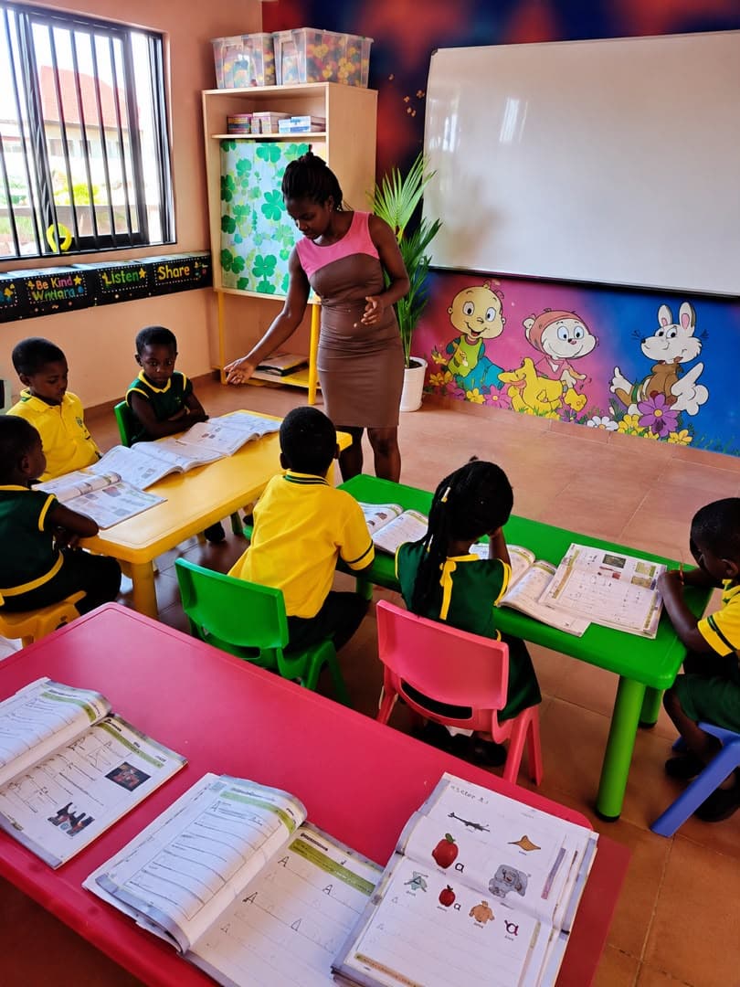 Early Years learners reading with their teacher in a colourful preschool classroom